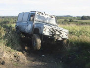 Land Rover Defender 110 setting a trial with wheel in air